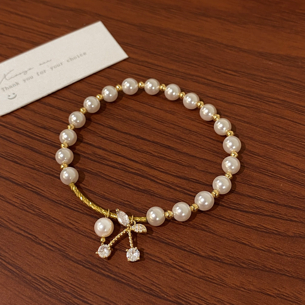 Pearl and bow charm bracelet