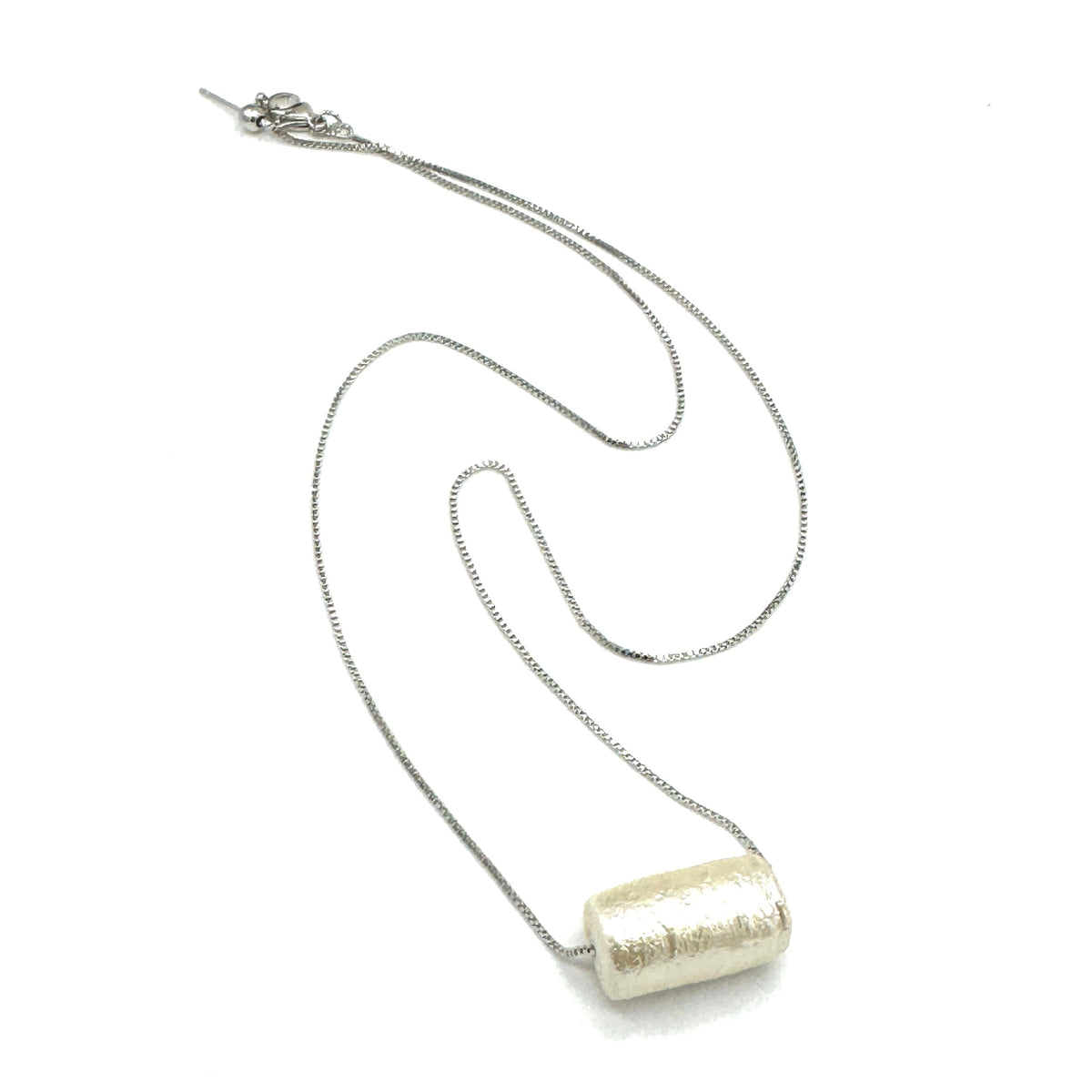 Silver necklace with a cylindrical pendant on a white background