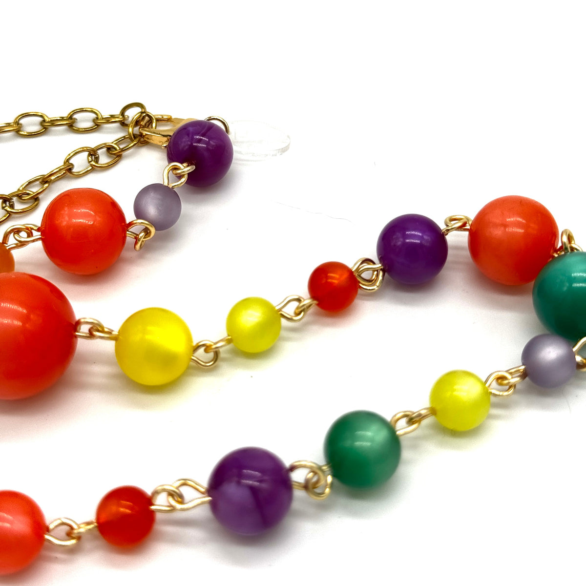 Colorful beaded necklace with gold chain on a white background