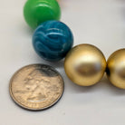 Colorful beads and a quarter on a white background