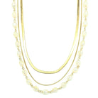 Three-strand necklace with gold chains and clear-colored beads on a white background