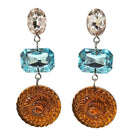 Pair of earrings with blue and orange gems on a white background