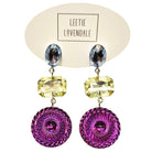 Colorful earrings with purple circular designs on a Leetie Lovendale branded card.