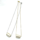 Two necklaces with tubular pearl pendant on a white background