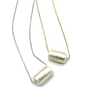 Two necklaces with cylindrical pendants on a white background