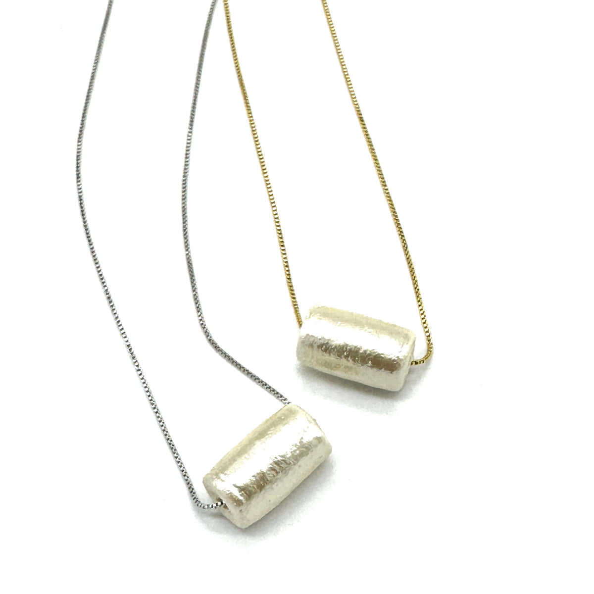 Two necklaces with cylindrical pendants on a white background