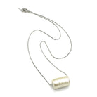 Silver necklace with a cylindrical pendant on a white background