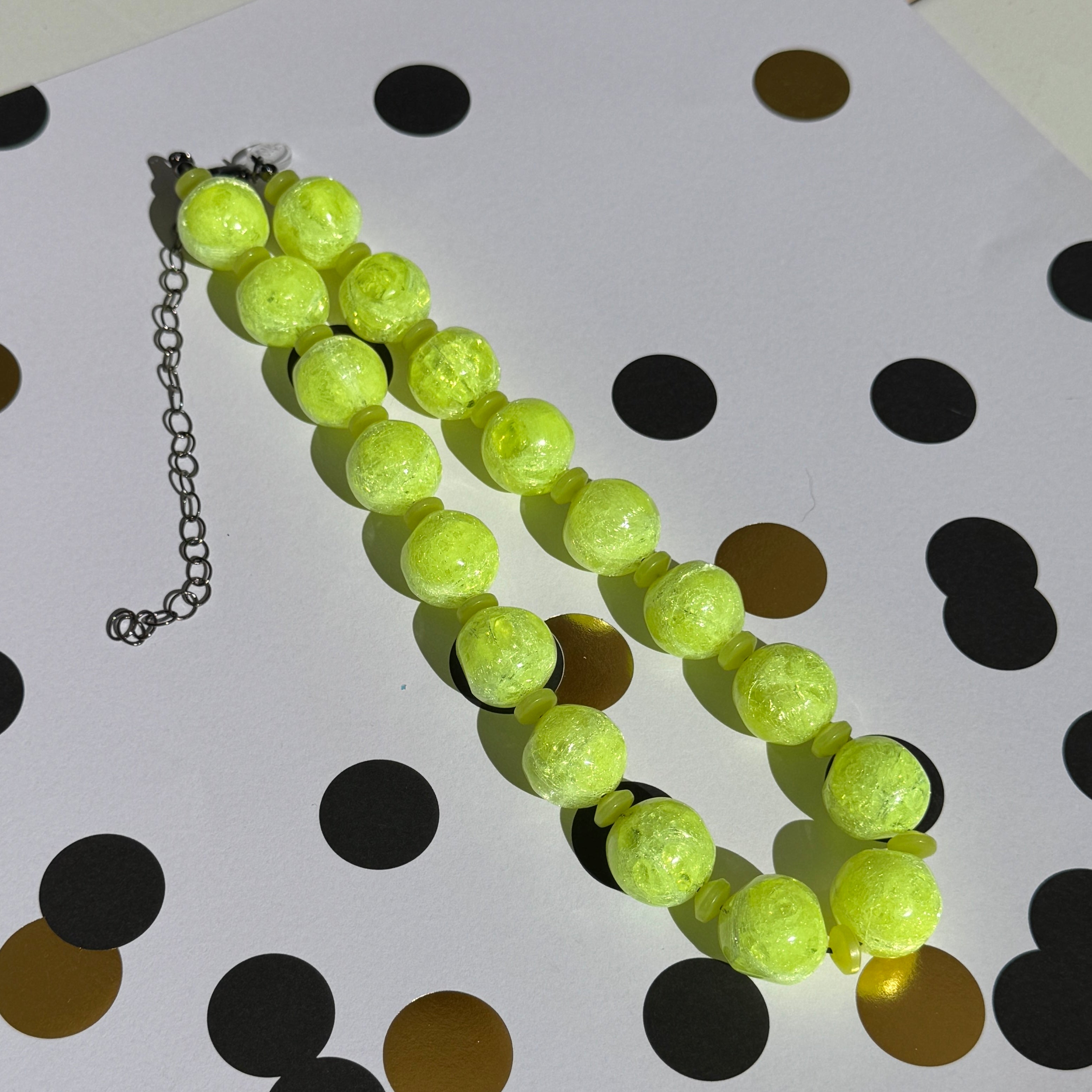 Necklace with bright yellow beads on a polka dot background