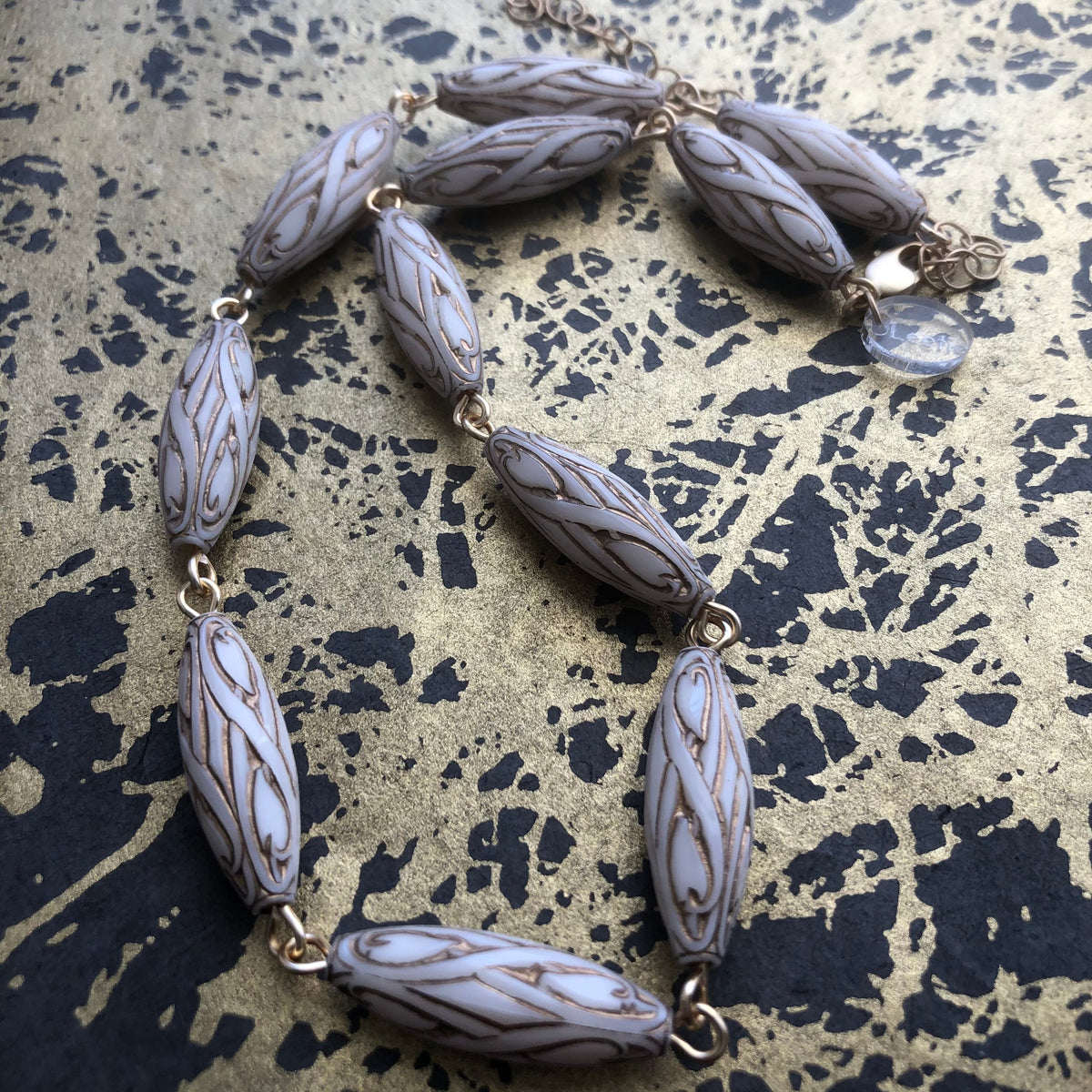 gold and white necklace