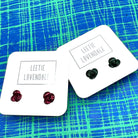 Two pairs of earrings on 'Leetie Lovendale' branded cards against a blue and green patterned background.