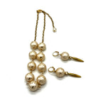 Half chain and half beaded necklace, featuring gold chain and floral etched pearl lucite beads, alongside matching dangle earrings.