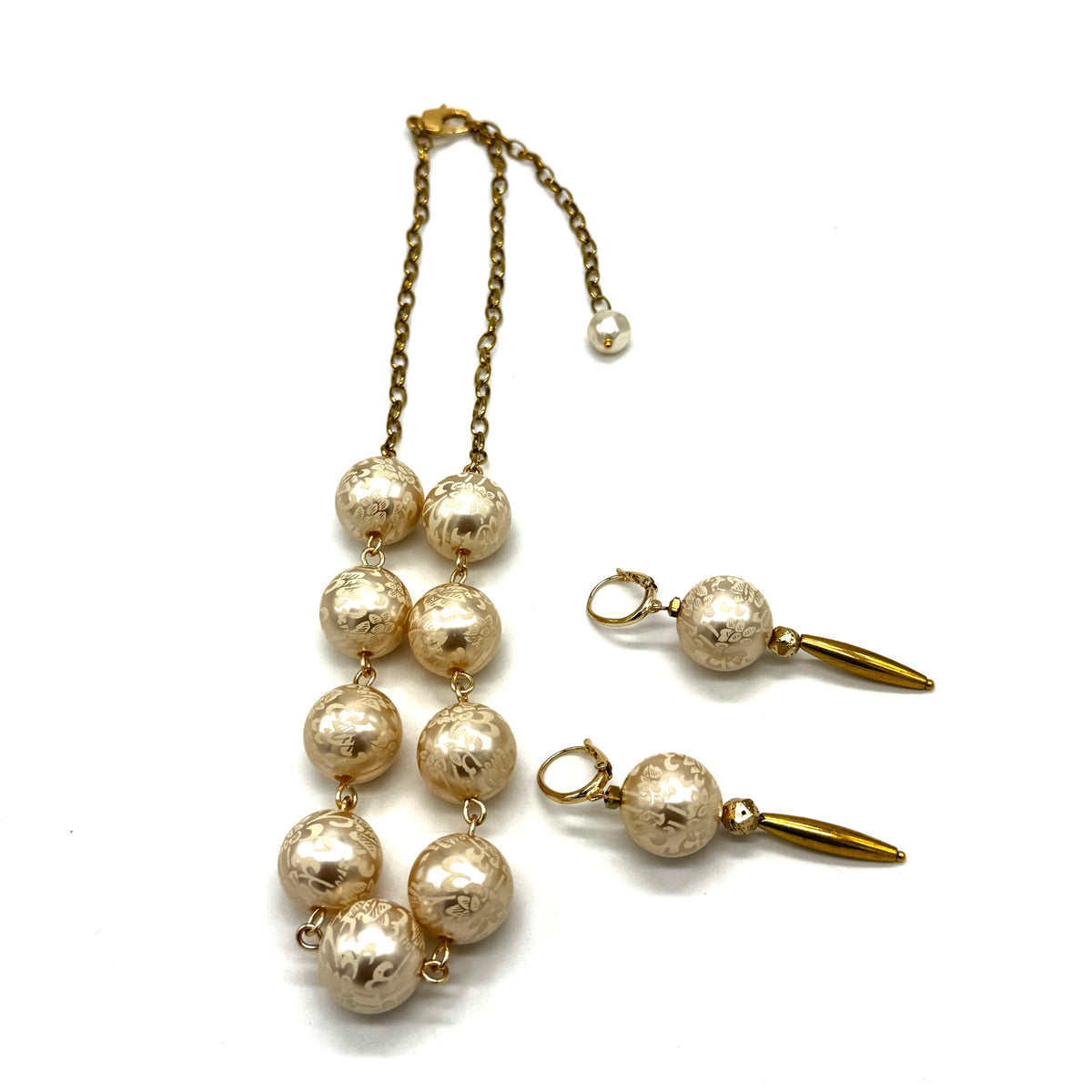 Half chain and half beaded necklace, featuring gold chain and floral etched pearl lucite beads, alongside matching dangle earrings.