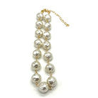 A pearl necklace with textured, hammered white pearls linked by gold-toned chains and connectors, featuring a gold-toned extender chain on a white background.