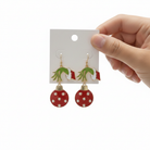 Grinch Christmas ornament dangle earrings in red with pearl accents on white background