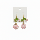 Light pink Christmas ornament dangle earrings with pearl accents on white background
