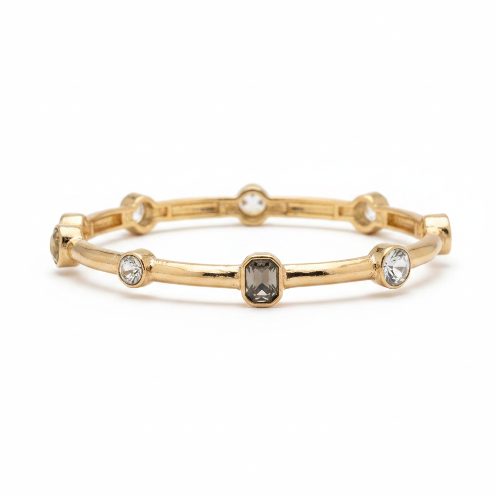 Gold bamboo bangle bracelet with clear crystal stones on white background